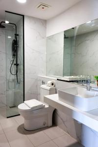 a bathroom with a toilet and a sink and a mirror at Kivana Suite, Vetro 11 by Ayuhouz in Kota Kinabalu