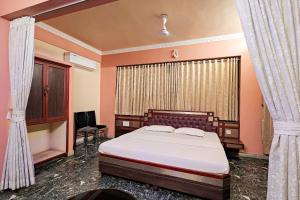 a bedroom with a bed and a window at Landmark INN in Kāsaragod