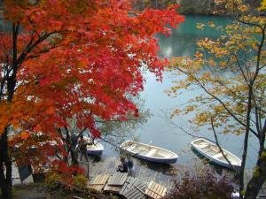 three boats are docked on a dock on a lake at Pension Hana Kirin in Kitashiobara