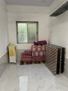 a room with a pile of blankets and a window at Golden Wave Cottage in Revadanda +14 photos