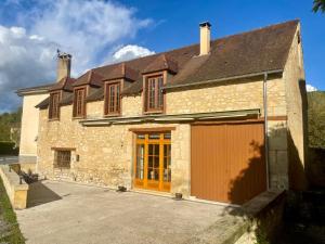 een oud stenen huis met een grote garage bij Les Terrasses de Daglan in Daglan
