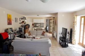 een woonkamer met twee witte banken en een tv bij Les Terrasses de Daglan in Daglan