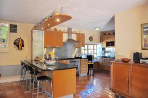 een keuken met een eiland met barkrukken bij Les Terrasses de Daglan in Daglan