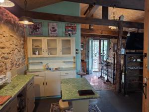 墨累桥A La Folly The Retreat的厨房配有白色橱柜和石墙