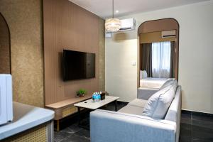 a living room with a couch and a tv in a room at Kivana Suite, Vetro 11 by Ayuhouz in Kota Kinabalu