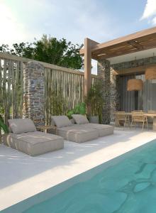 a patio with two beds next to a swimming pool at Casa Euphoria in Elounda