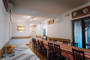 a dining room with a long table and chairs at Double room in Pensiunea Nossa Panzió in Corunca