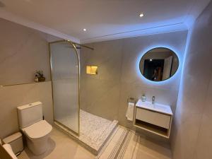 une salle de bains avec toilettes, lavabo et miroir dans l'établissement Luxe Stay Somerset West 4, à Somerset West 7 autres photos