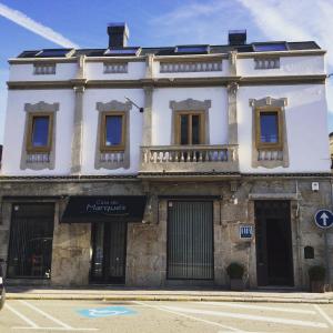 ein weißes Gebäude mit Balkon auf einer Straße in der Unterkunft Casa do Marqués in Baiona