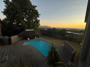 - une piscine avec un parasol sur la terrasse dans l'établissement Luxe Stay Somerset West 4, à Somerset West