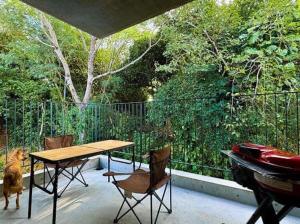 een terras met een tafel, een piano en een hond bij RYUKYU BREEZE 1棟貸し 天然ビーチまで徒歩30秒 プライベートプール付きVilla 北部 in Nago