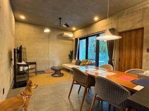 een hond in een woonkamer met een tafel bij RYUKYU BREEZE 1棟貸し 天然ビーチまで徒歩30秒 プライベートプール付きVilla 北部 in Nago +191 foto's