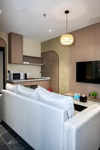 a living room with a white couch and a kitchen at Kivana Suite, Vetro 11 by Ayuhouz in Kota Kinabalu +71 photos