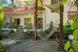 ein Haus mit einer Hängematte im Vorgarten in der Unterkunft Kenwood's Farmstay - 6bhk with private pool in Zadapoli