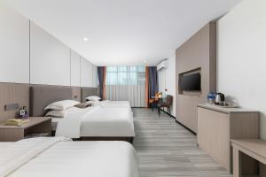 a hotel room with three beds and a flat screen tv at Good East Hotel in Guangzhou +29 photos