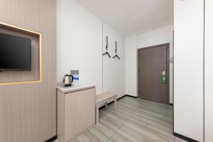 a hotel room with a television and a corridor at Good East Hotel in Guangzhou