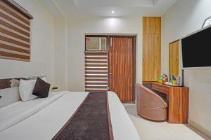 a hotel room with a bed and a television at Hotel Church House - Rohini I Near Metro I Spacious Rooms I Friendly Staff I Most Preferred Hotel In Rohini in Delhi