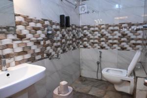 a bathroom with a sink and a toilet at Hotel Kailash Heaven in Madikeri