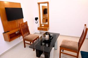 a living room with a table and two chairs at Hotel Kailash Heaven in Madikeri