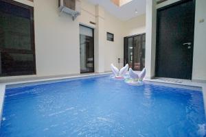een zwembad met twee witte pelikanen in een huis bij Villa Aruna Kolam Renang Private in Godean