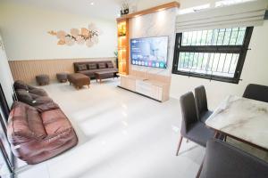 een woonkamer met een bank en een flatscreen-tv bij Villa Aruna Kolam Renang Private in Godean