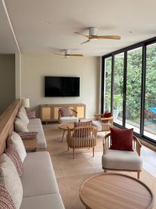 een woonkamer met banken en een flatscreen-tv bij TWIN PALMS 'Beach House' - New surf front location in Thulusdhoo