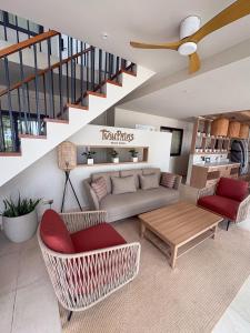 een woonkamer met een bank en een tafel bij TWIN PALMS 'Beach House' - New surf front location in Thulusdhoo