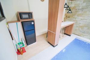 een kleine keuken met een koelkast en een magnetron bij Villa Aruna Kolam Renang Private in Godean