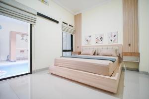 een slaapkamer met een groot bed en een groot raam bij Villa Aruna Kolam Renang Private in Godean +38 foto's