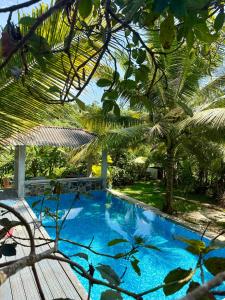 een blauw zwembad in een tuin met palmbomen bij Tiny Royal Palace in Unawatuna