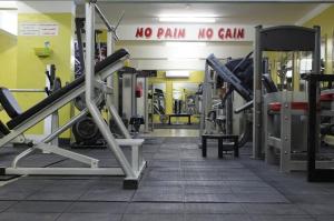 a gym with lots of machines and a sign saying no pain no gain at سمارا أدم SAMARA Adam in Ādam