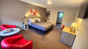 een hotelkamer met een bed en een rode stoel bij Carramar Motor Inn in Palmerston North