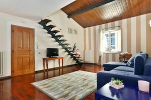 Dimora Anfiteatro في لوكّا: غرفة معيشة مع أريكة زرقاء ودرج حلزوني