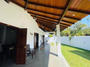 een patio met een houten dak en stoelen bij Legacy Weligama in Weligama