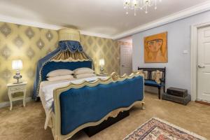 a bedroom with a blue bed with a blue canopy at Kent Cottage in Nuwara Eliya