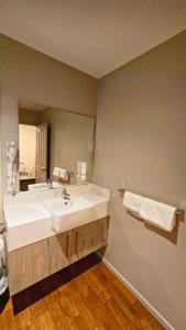 een badkamer met twee wastafels en een grote spiegel bij Carramar Motor Inn in Palmerston North +163 foto's
