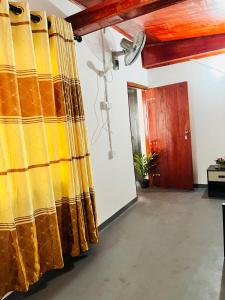 a room with yellow curtains and a door at Azure Coast Villa in Ahangama