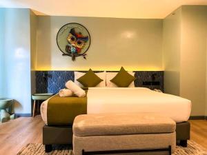 ein Hotelzimmer mit 2 Betten und einer Ottomane in der Unterkunft Tuscany Basic Urban Stay in Baguio City