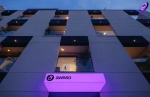 a large building with a purple sign in front of it at Aweso Limassol in Limassol