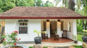 a small white house with a red roof at Calm Villa in Mihiripenne