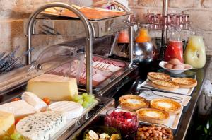 ein Buffet mit Käse, Gebäck und anderen Speisen in der Unterkunft Grand Hotel Saint Michel in Paris