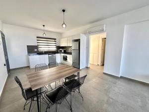 een keuken en eetkamer met een houten tafel en stoelen bij Retreat, block A2, unit 1 in Ayios Nikolaos