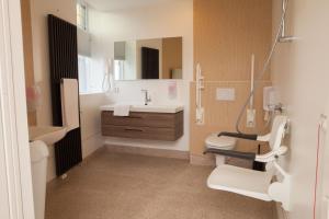 een badkamer met een wastafel, een toilet en een spiegel bij Stadslogement Kingsize in Sneek