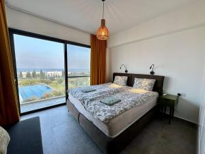 een slaapkamer met een bed en een groot raam bij Retreat block A2, unit 6 in Küçükerenköy