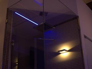 uma casa de banho com uma luz azul num chuveiro em Maga Mirì Relais Suite em Spinazzola