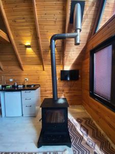 een open haard in een kamer met een houten muur bij Hidden Garden Bungalow in Trabzon