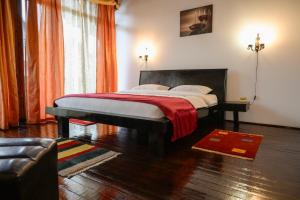 ein Schlafzimmer mit einem großen Bett mit einer roten Decke in der Unterkunft Casa Frent in Predeal