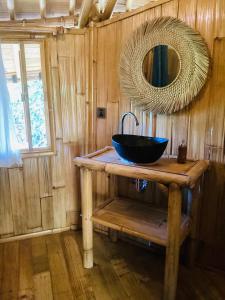 een badkamer met een zwarte wastafel en een spiegel bij Les Terrasses Ceningan in Nusa Lembongan