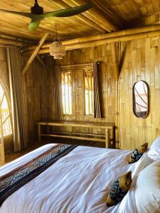 een groot bed in een kamer met houten wanden bij Les Terrasses Ceningan in Nusa Lembongan +86 foto's