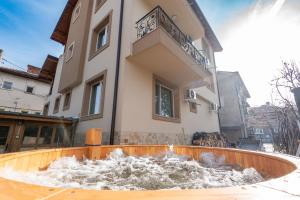 a water fountain in front of a building at Къща за гости Оскови in Velingrad